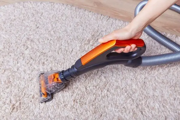 Person using handheld carpet cleaner