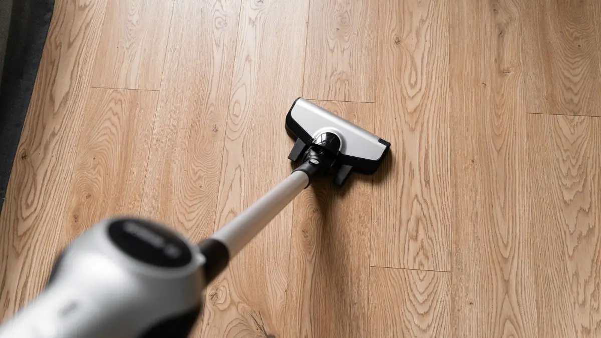 a person vacuuming a laminate floor