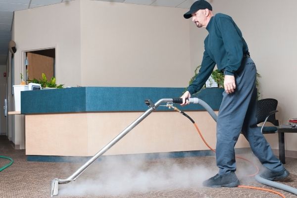 a man steam cleaning a carpet
