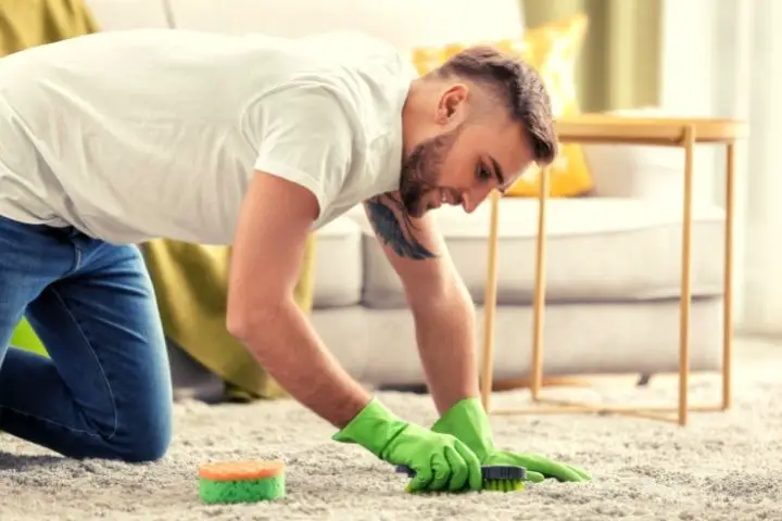Man Scrabbing A Carpet With Brush