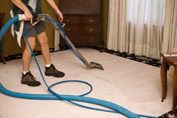 Man Steam Cleaning Carpet