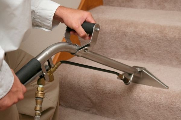 Person Keeping Carpet Stairs Clean Using A Steam Cleaner
