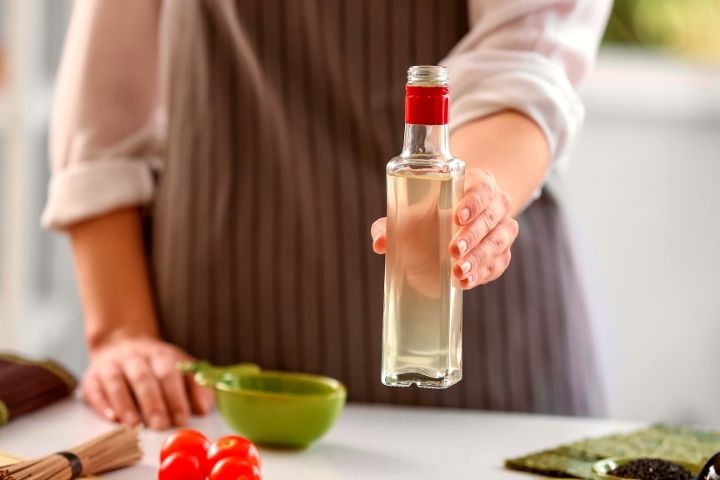 A Woman Is Holding Vinegar In Hand