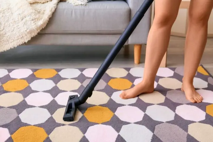 A Woman Is Vacuuming A Carpet