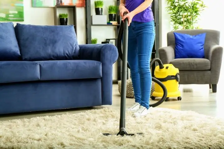 A Woman Is Vacuuming Carpet