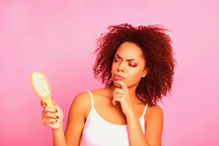 A Woman Looks On A Hair Brush